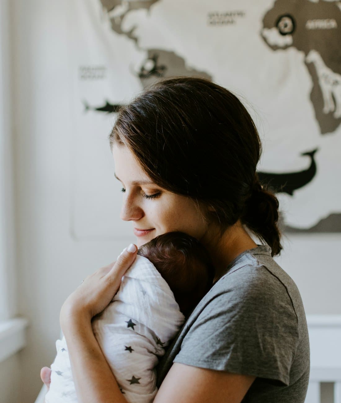 A mother holding her sleeping baby against her chest