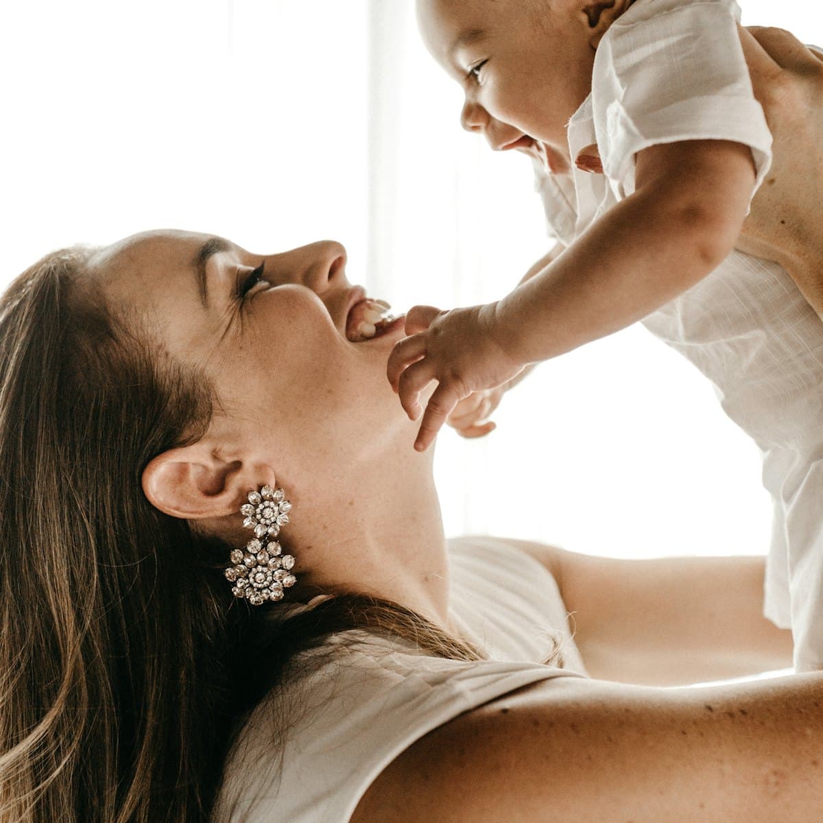 A laughing mother playing with her baby